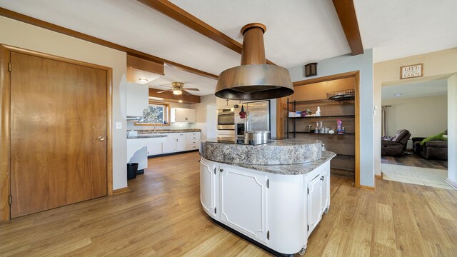 living room with light wood-type flooring, a fireplace, and beamed ceiling