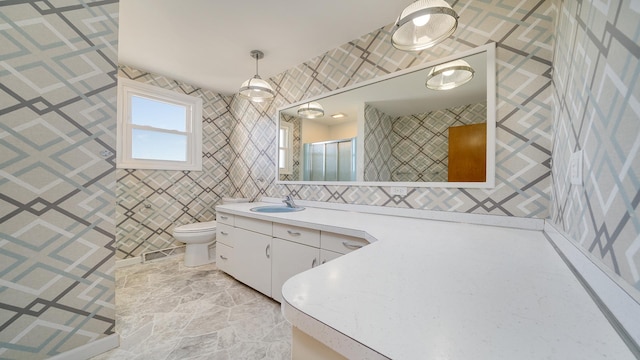 bathroom featuring toilet, a shower with shower door, and vanity