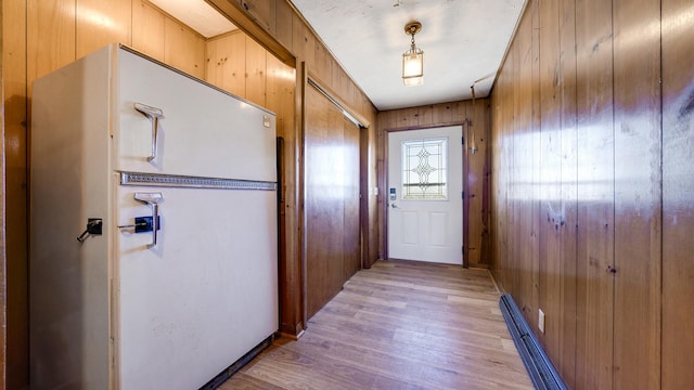 entryway with wooden walls and light hardwood / wood-style floors