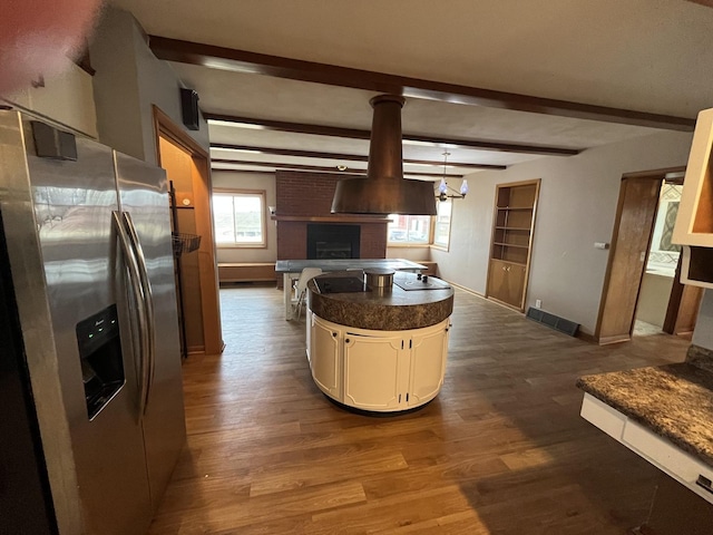 kitchen featuring beamed ceiling, stainless steel fridge, dark wood-type flooring, and hanging light fixtures