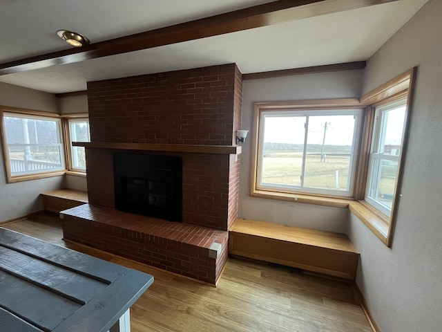 living room with a brick fireplace and light hardwood / wood-style floors