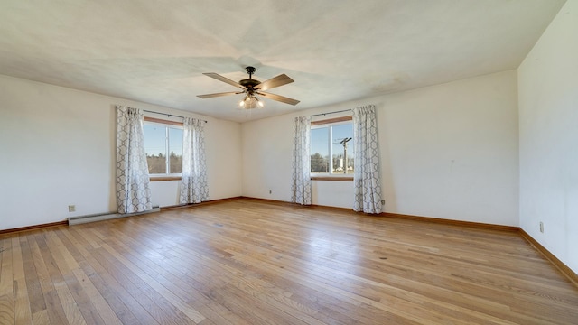 unfurnished room with ceiling fan, plenty of natural light, light wood-type flooring, and baseboard heating