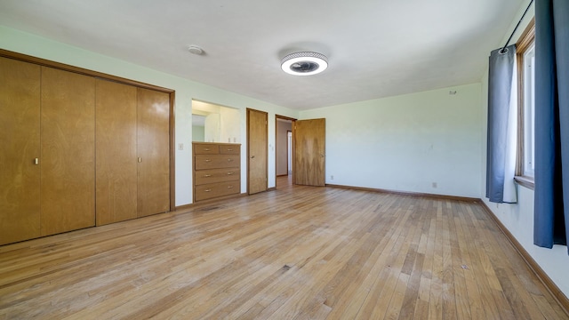 unfurnished bedroom featuring light hardwood / wood-style floors and a closet