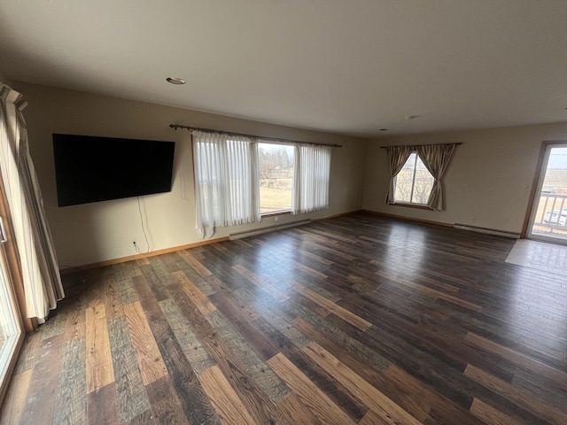 empty room with dark hardwood / wood-style floors and baseboard heating