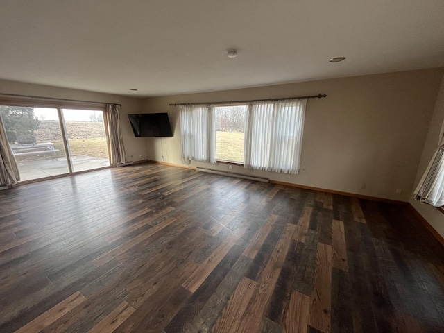 empty room with plenty of natural light, dark hardwood / wood-style floors, and a baseboard radiator