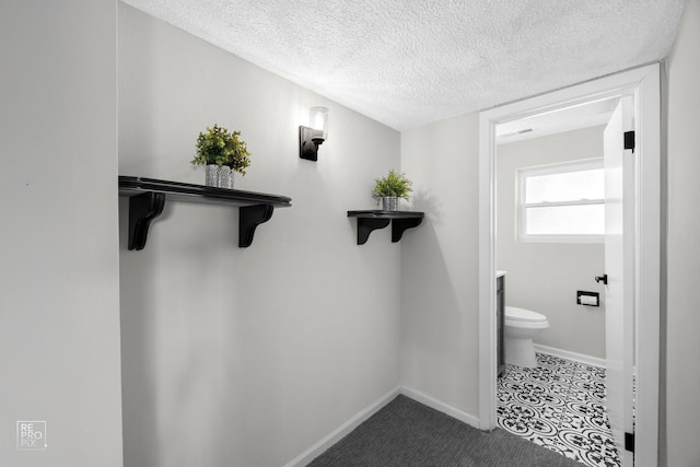 bathroom with toilet, vanity, and a textured ceiling