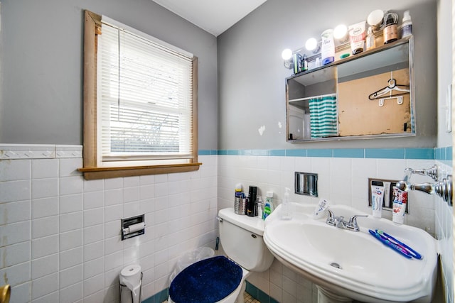 bathroom with tile walls, sink, and toilet