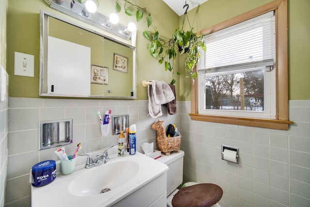 bathroom featuring vanity, toilet, and tile walls