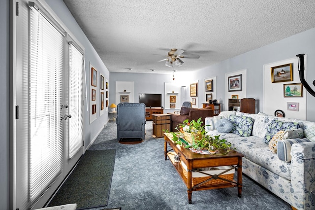 living room featuring ceiling fan, dark carpet, and a textured ceiling