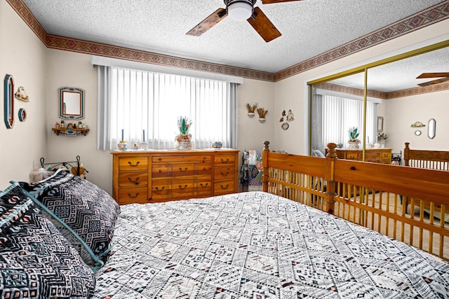 bedroom with multiple windows, ceiling fan, and a textured ceiling