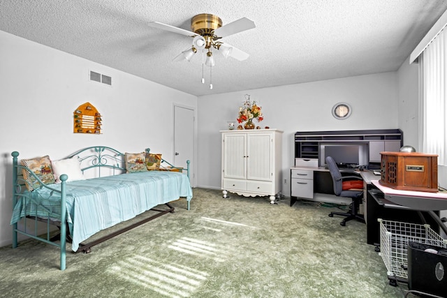 carpeted bedroom featuring ceiling fan and a textured ceiling