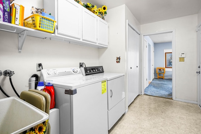 laundry room featuring sink, washing machine and dryer, and cabinets