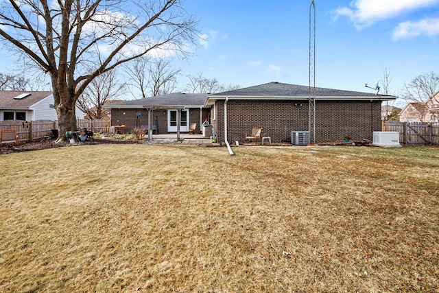 rear view of house featuring a patio, central AC unit, and a lawn