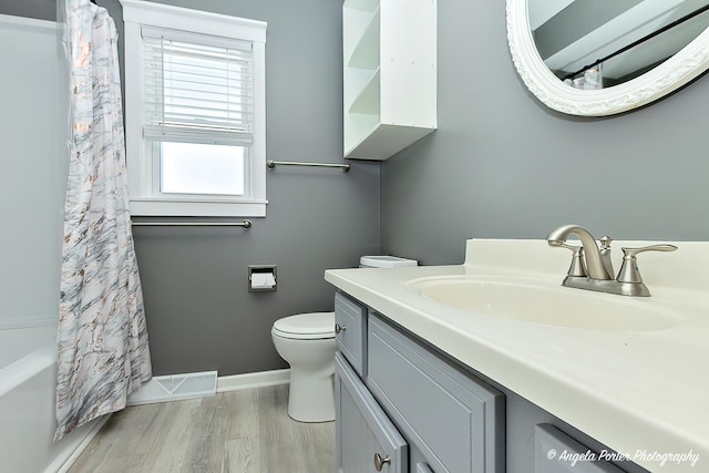 full bathroom featuring vanity, hardwood / wood-style floors, toilet, and shower / bath combo with shower curtain