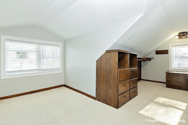 carpeted bedroom featuring vaulted ceiling and multiple windows