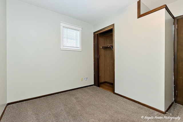 unfurnished bedroom with a walk in closet, carpet flooring, and a closet