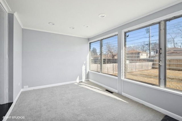 spare room with ornamental molding and carpet flooring