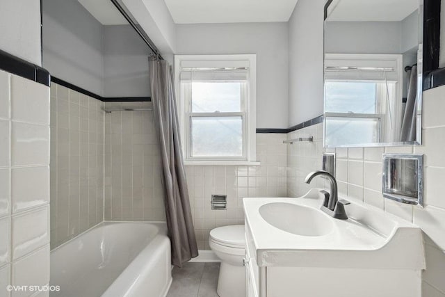 full bathroom featuring shower / bathtub combination with curtain, tile patterned floors, vanity, tile walls, and toilet