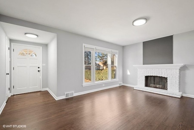 unfurnished living room featuring dark hardwood / wood-style flooring and a fireplace