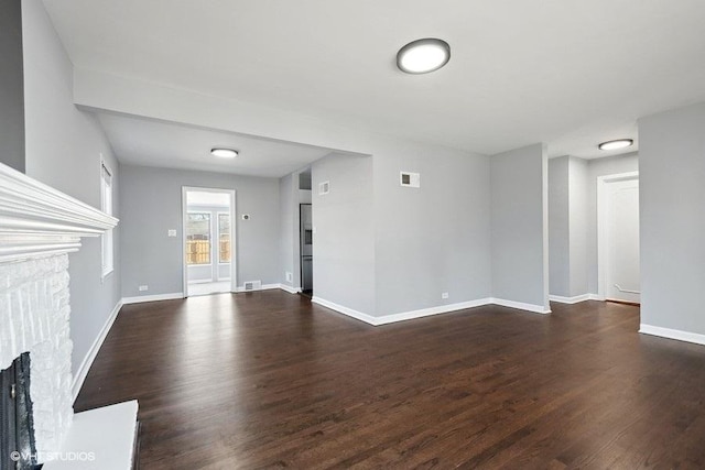 unfurnished living room with dark wood-type flooring