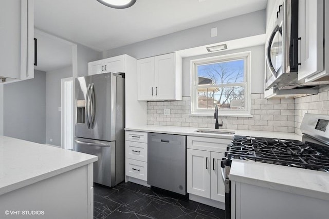 kitchen featuring sink, white cabinetry, stainless steel appliances, and tasteful backsplash