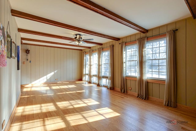 unfurnished room featuring ceiling fan, beam ceiling, and light hardwood / wood-style flooring