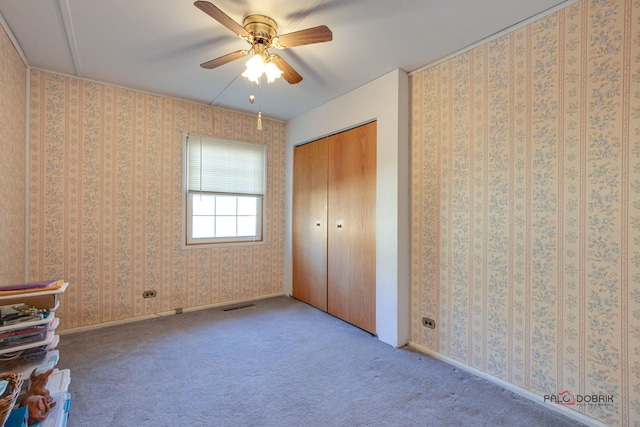 unfurnished bedroom with ceiling fan, light colored carpet, and a closet