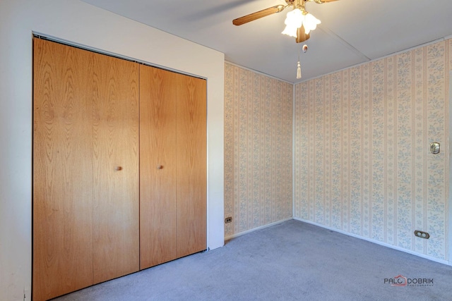 unfurnished bedroom with ceiling fan, carpet floors, and a closet