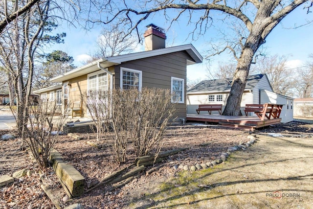 view of home's exterior with a wooden deck and a hot tub