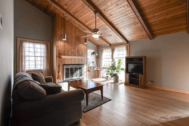 living room featuring high vaulted ceiling, beamed ceiling, wooden ceiling, and a healthy amount of sunlight