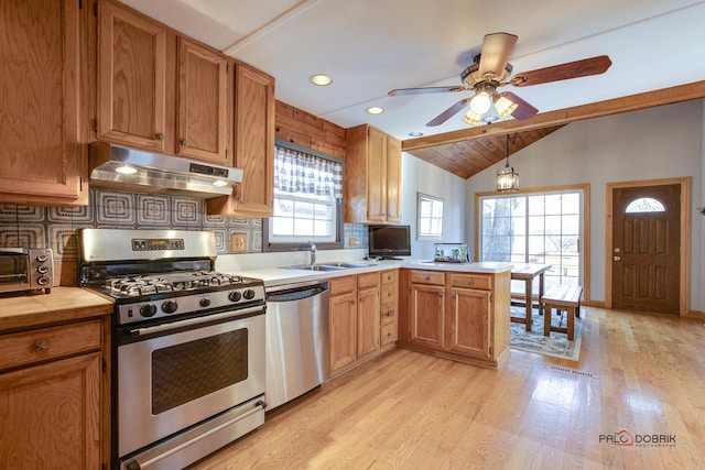 kitchen featuring appliances with stainless steel finishes, tasteful backsplash, vaulted ceiling with beams, sink, and kitchen peninsula