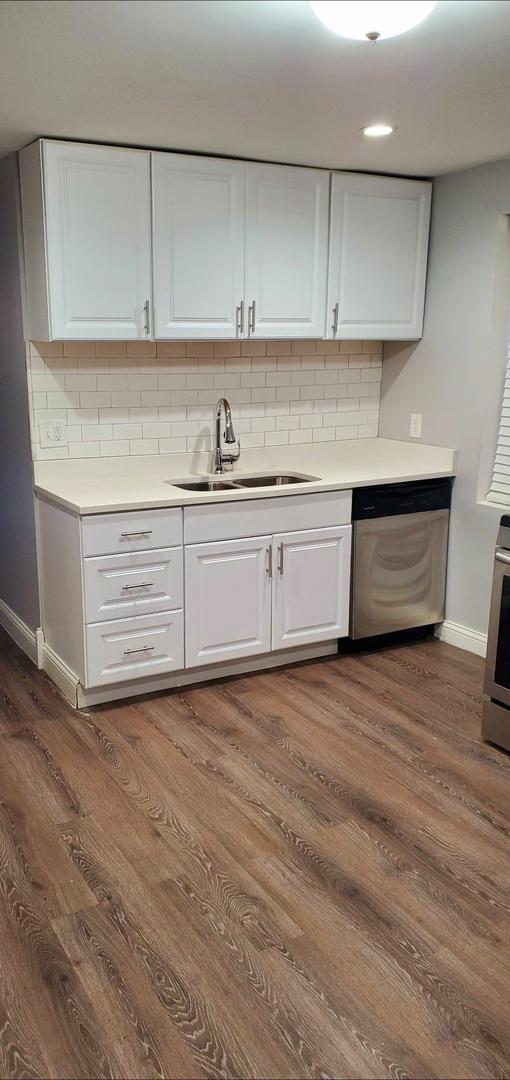 kitchen featuring sink, stainless steel dishwasher, and white cabinets