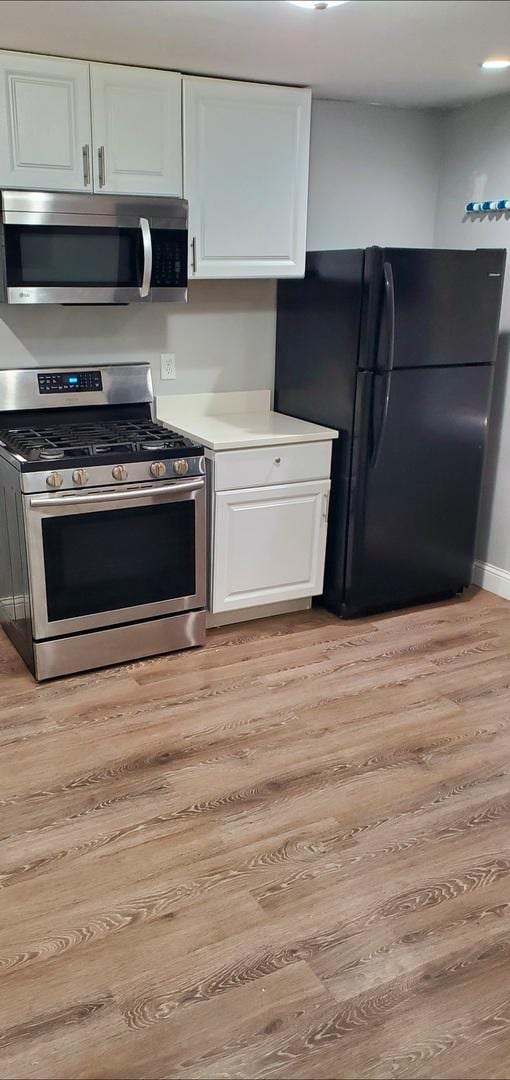 kitchen featuring white cabinetry, stainless steel appliances, and light hardwood / wood-style floors