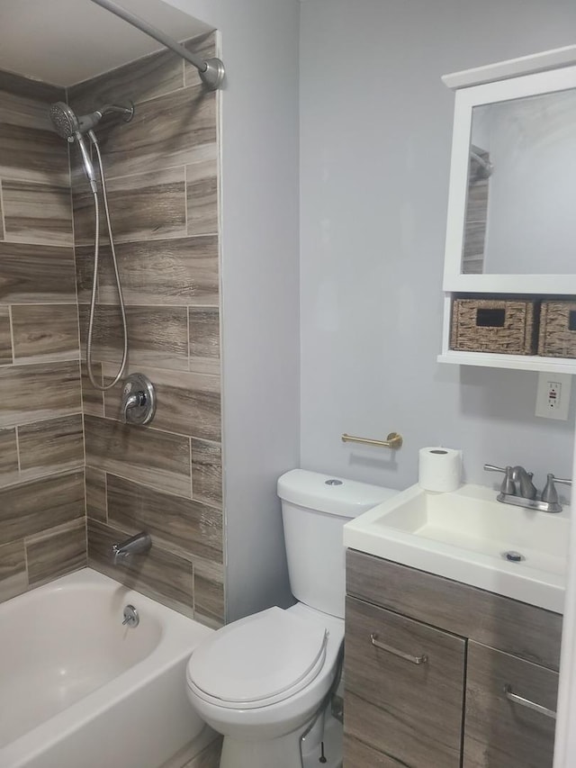 full bathroom featuring vanity, tiled shower / bath, and toilet