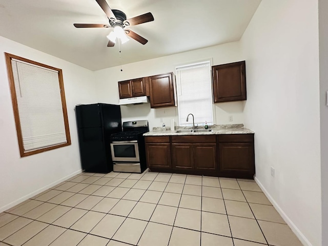 kitchen with black fridge, dark brown cabinetry, stainless steel range oven, and sink