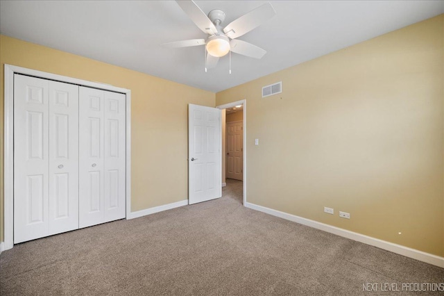 unfurnished bedroom featuring a ceiling fan, carpet, visible vents, baseboards, and a closet