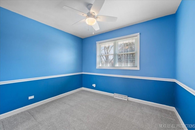 carpeted empty room featuring visible vents, ceiling fan, and baseboards