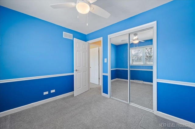 unfurnished bedroom featuring visible vents, baseboards, carpet, a closet, and a ceiling fan