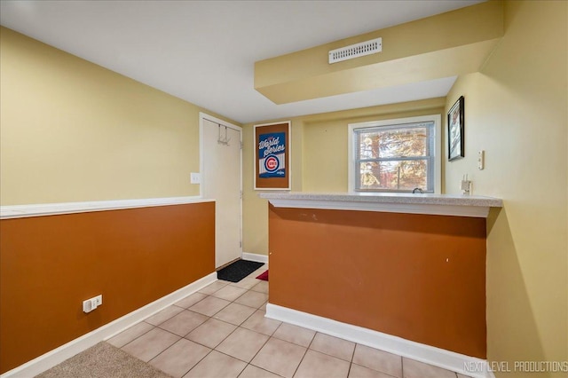 bar with visible vents, baseboards, and light tile patterned flooring