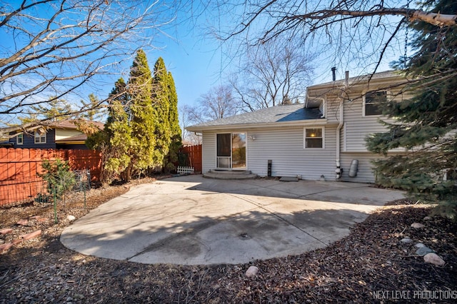 back of house with entry steps, a patio, fence, and a shingled roof