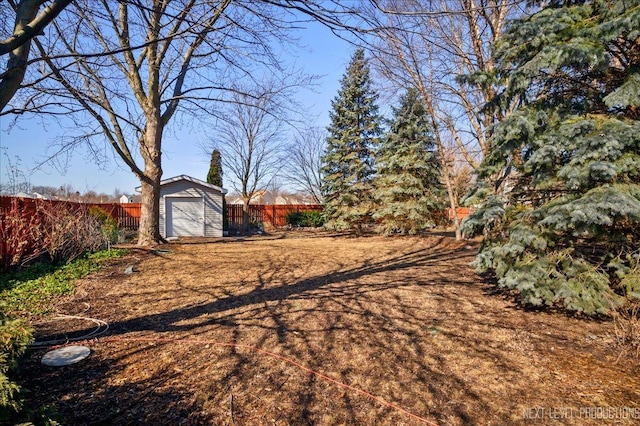 view of yard featuring an outbuilding, a storage unit, and a fenced backyard