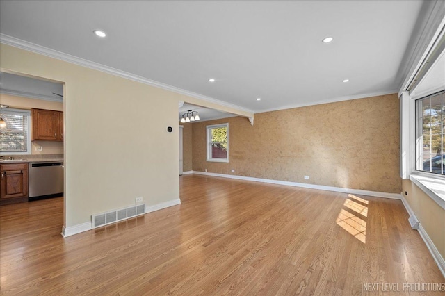 unfurnished living room featuring visible vents, baseboards, crown molding, and light wood-style floors