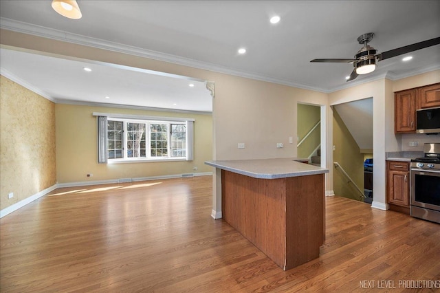 kitchen featuring brown cabinetry, wood finished floors, light countertops, appliances with stainless steel finishes, and open floor plan