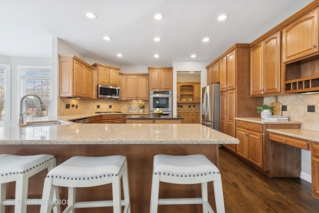 kitchen featuring sink, stainless steel appliances, and light stone countertops