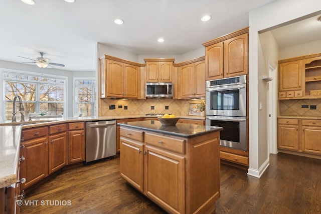 kitchen featuring a kitchen island, appliances with stainless steel finishes, sink, and dark hardwood / wood-style flooring