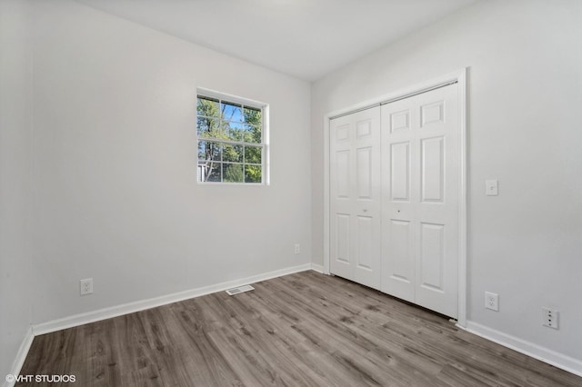 unfurnished bedroom featuring hardwood / wood-style flooring and a closet