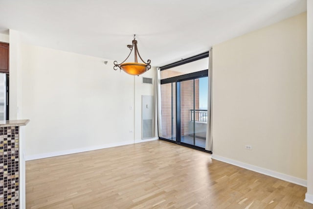 unfurnished room with expansive windows and light wood-type flooring