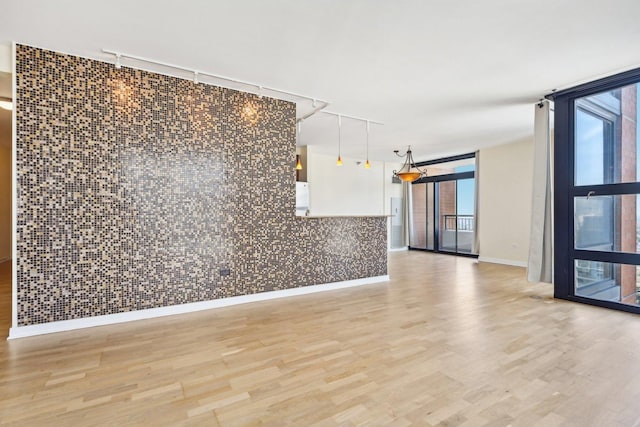 unfurnished room with floor to ceiling windows and wood-type flooring