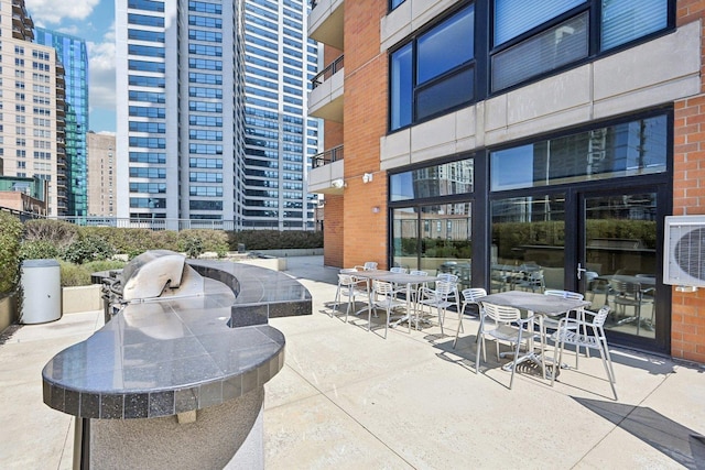 view of property's community with area for grilling, a patio, and ac unit