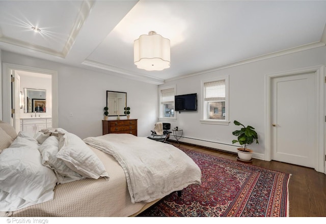 bedroom with dark hardwood / wood-style floors, crown molding, a baseboard heating unit, and ensuite bath